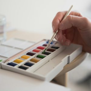 person holding white and green wooden chopsticks